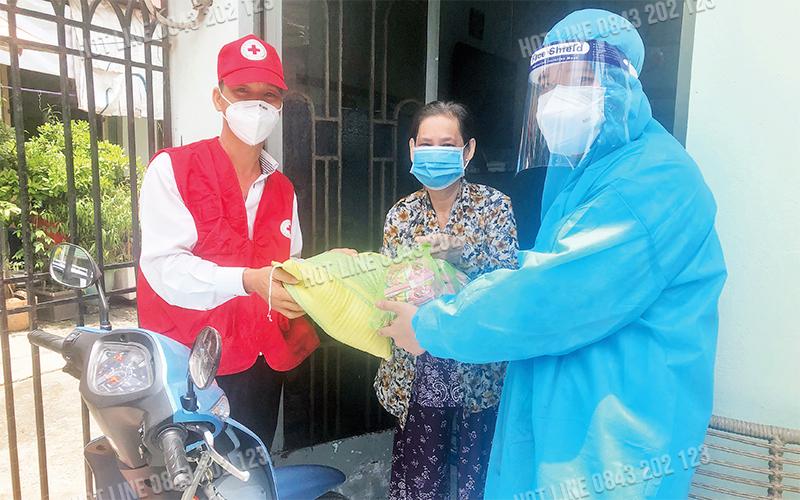 Tình nguyện viên Hội Chữ thập đỏ TP Hồ Chí Minh tặng quà cho F0 tại quận Bình Tân.